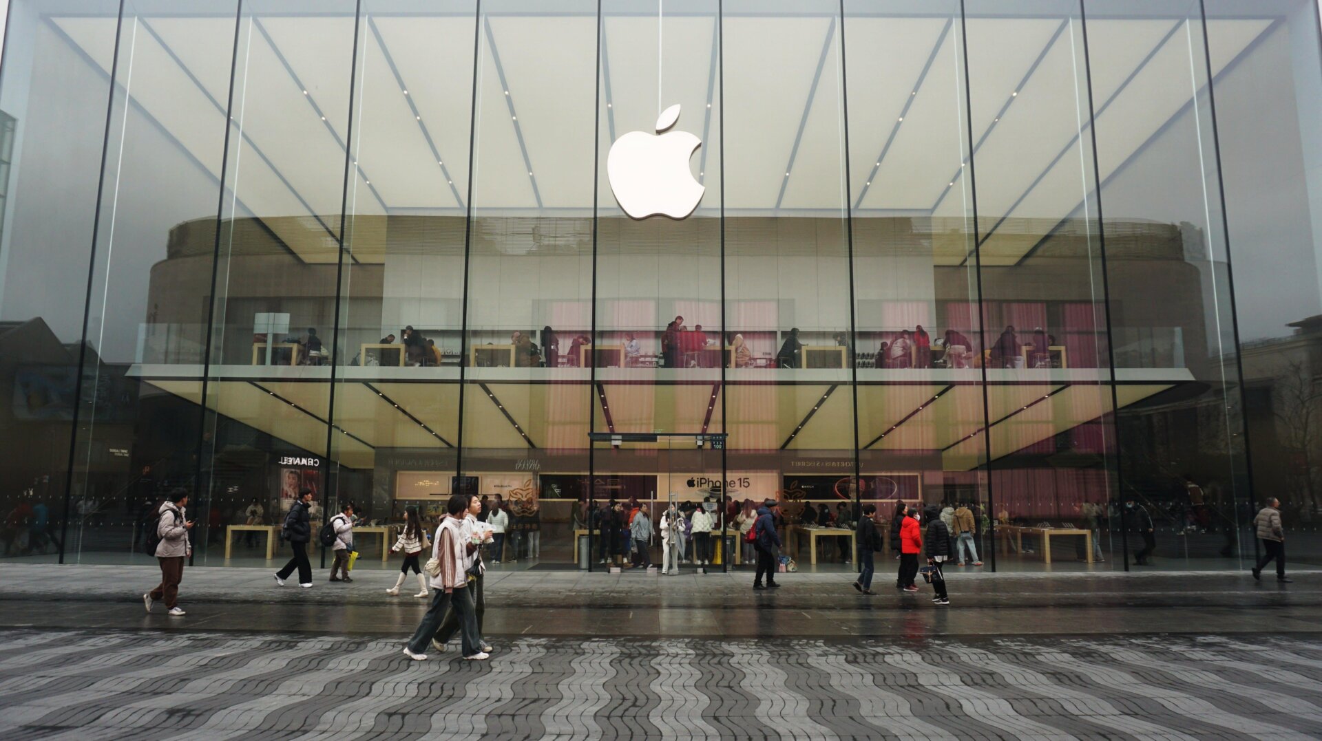 Photo d’archives de personnes passant devant un magasin phare d’Apple à Hangzhou, dans la province du Zhejiang, en Chine, le 20 février 2024.