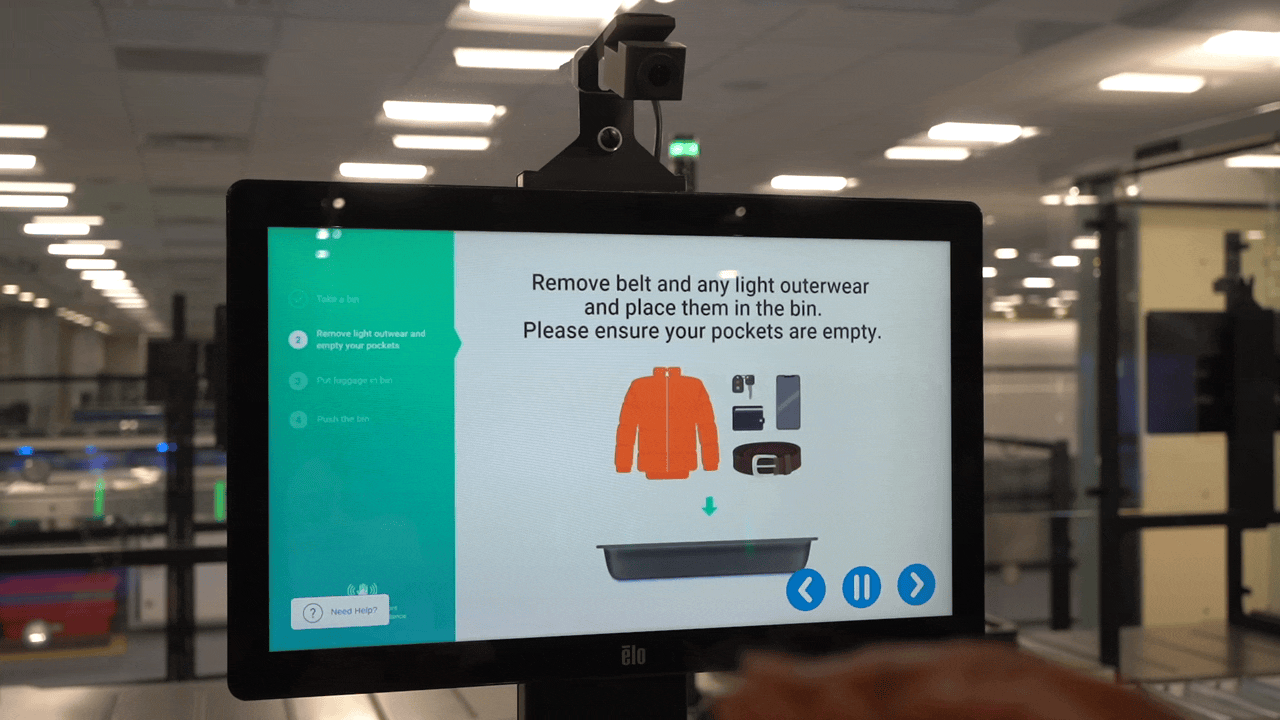 Dans cet extrait d’une vidéo de la TSA, une nouvelle ligne de sécurité « caisse automatique » est présentée avec la possibilité d’afficher de l’aide. du personnel à distance sur un moniteur vidéo.