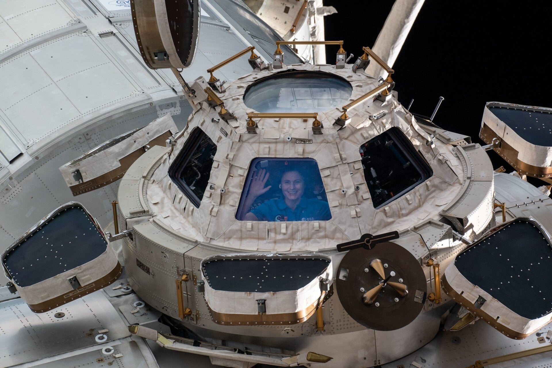 L’astronaute de l’ESA, Samantha Cristoforetti, regarde depuis une fenêtre de la coupole.