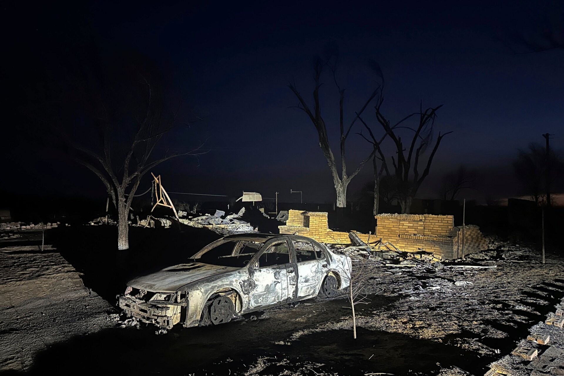 Un véhicule carbonisé se trouve près des ruines d’une maison après que la propriété ait été incendiée par l’incendie de Smokehouse Creek, le mercredi 28 février.  2024, à  Fritch, Texas.