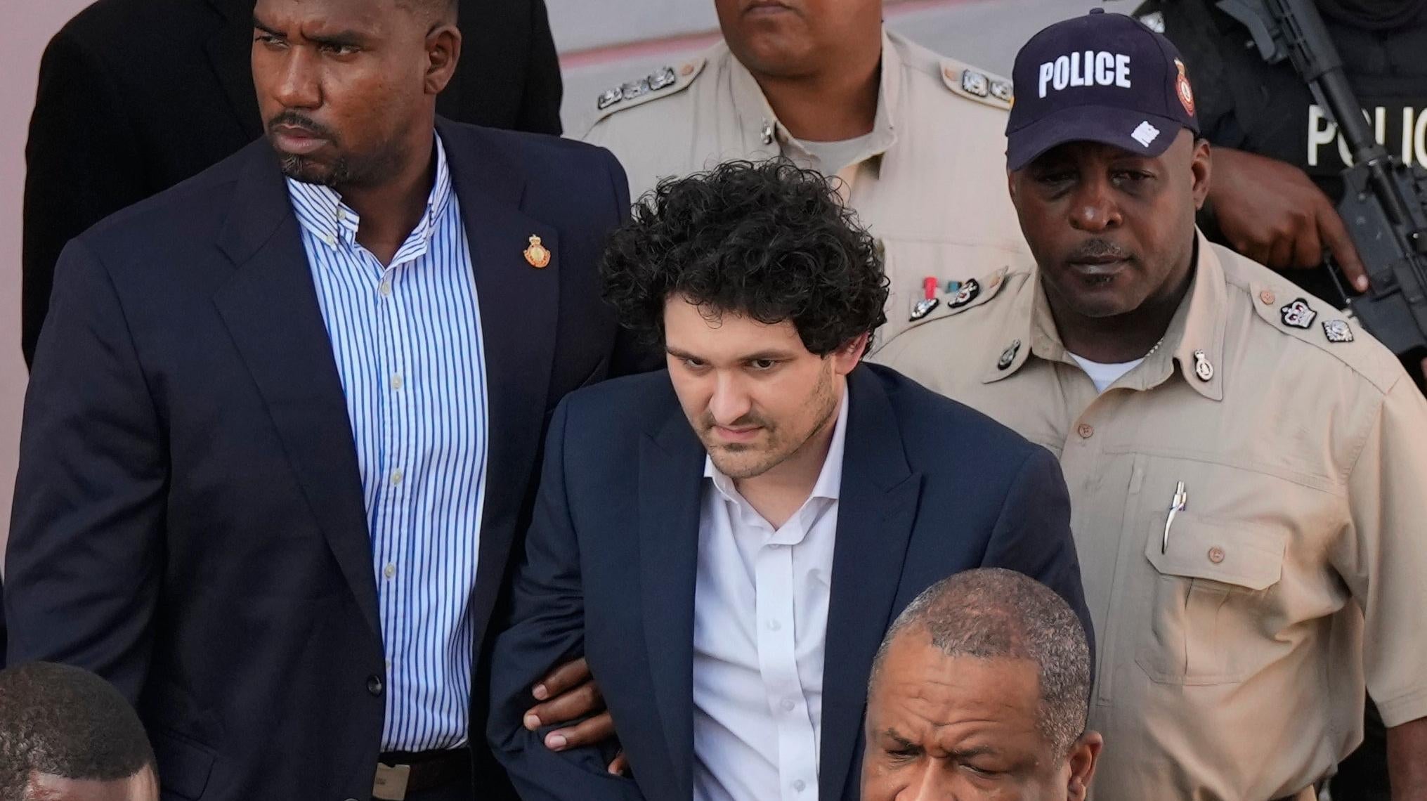 Le fondateur de FTX, Sam Bankman-Fried, au centre, est escorté hors d’un tribunal à Nassau, aux Bahamas, avant d’être extradé vers les États-Unis en décembre. . 19 2022.