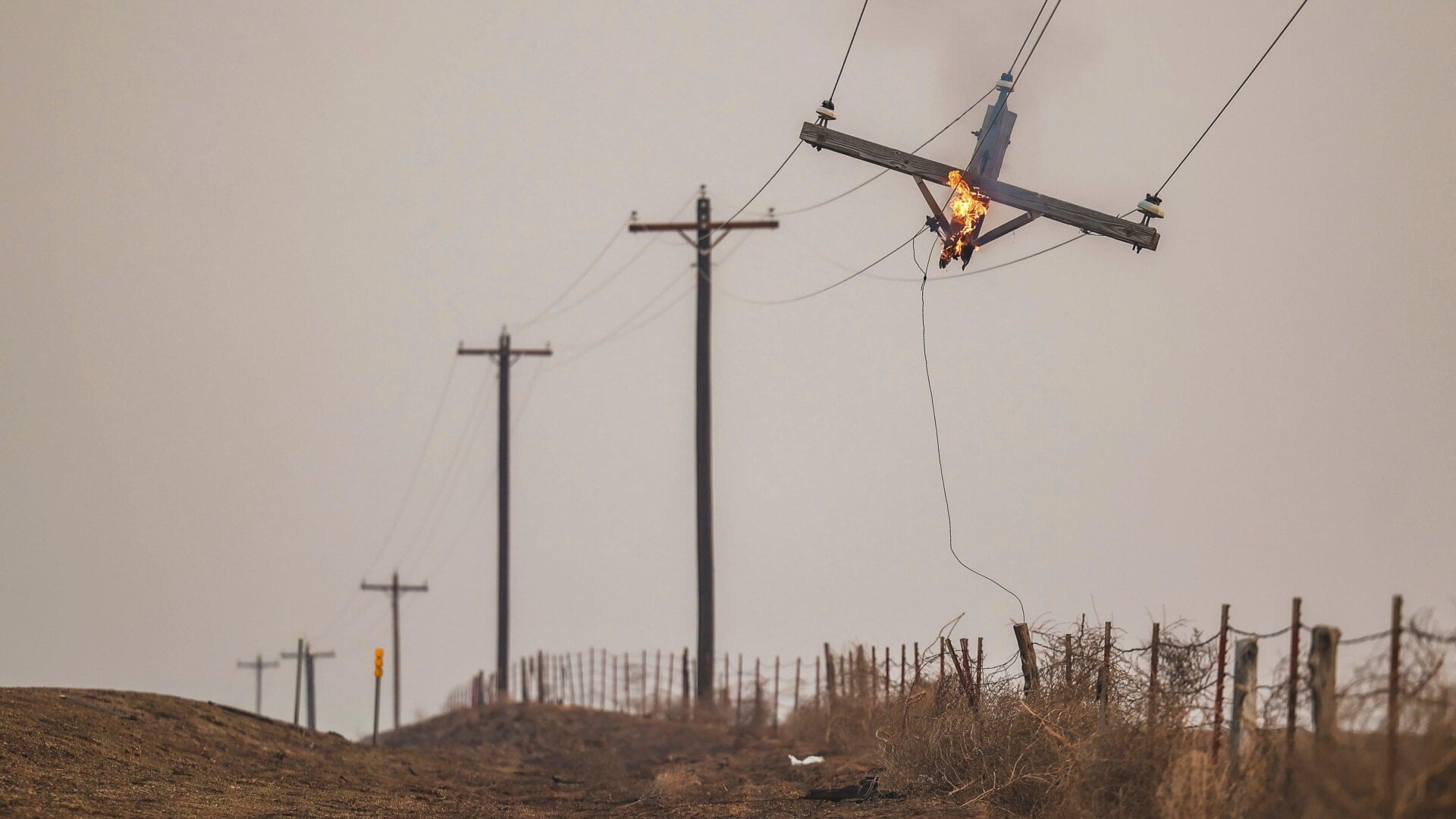 Un poteau téléphonique brûle à cause de l’incendie de Smokehouse Creek, le mercredi 28 février 2024, à Canadian, au Texas.