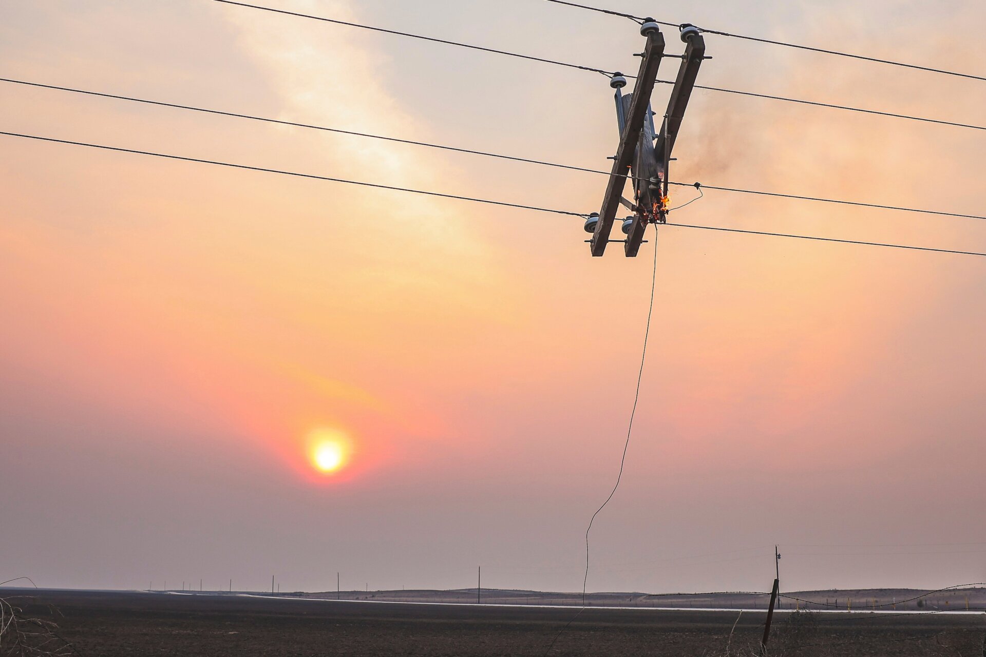 Un poteau téléphonique brûle à cause de l’incendie du ruisseau Smokehouse au coucher du soleil, le mercredi 28 février 2024, à Canadian, au Texas.