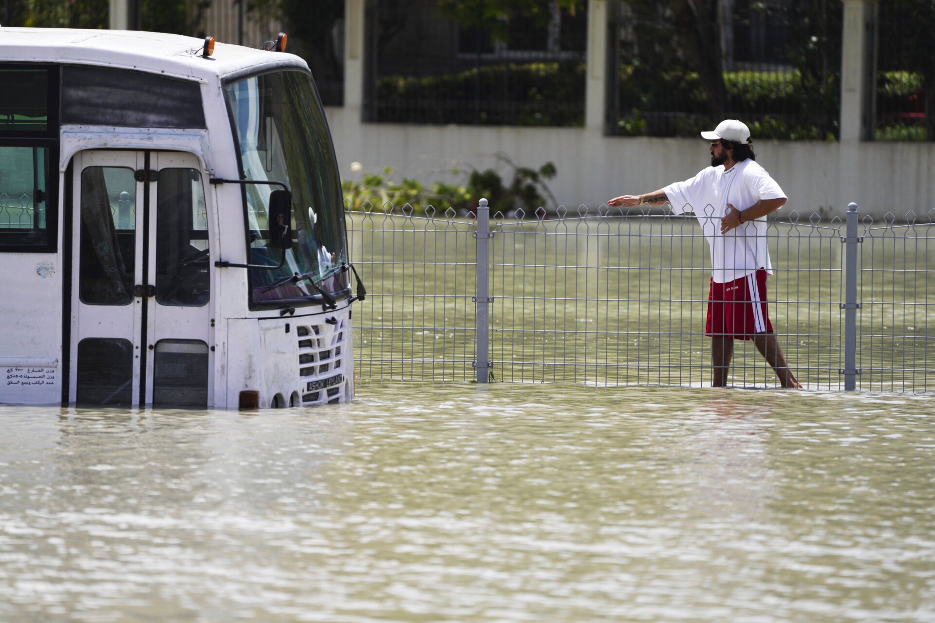 Un homme marche dans les eaux de crue à Dubaï, dans les Émirats arabes unis, le mercredi 17 avril 2024.