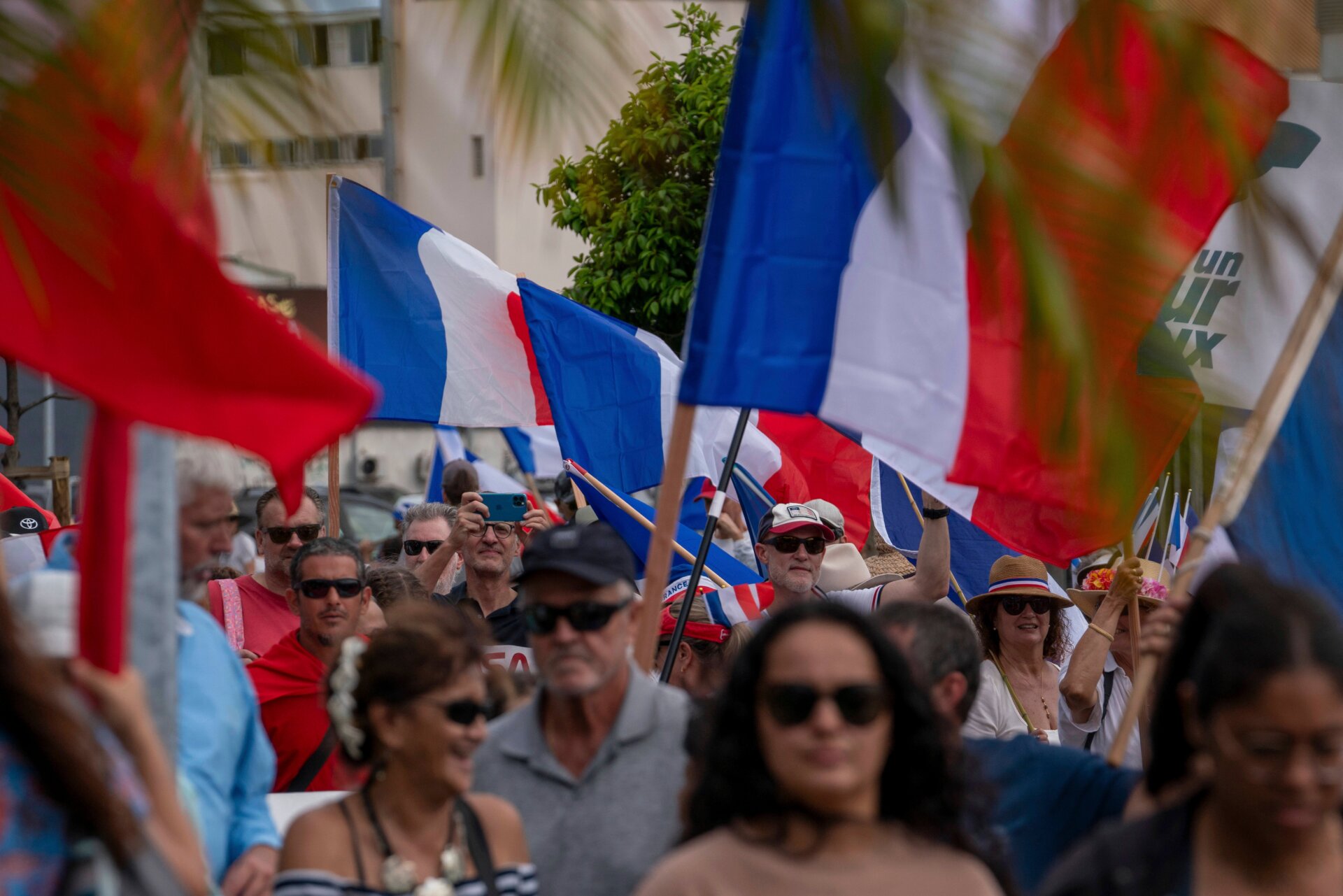 Des manifestants de plusieurs partis loyalistes brandissent des drapeaux nationaux français alors qu’ils défilent lors d’une manifestation pour soutenir l’élargissement de l’électorat du parti prochaines élections provinciales en Nouvelle-Calédonie, à Nouméa, le 13 avril 2024.