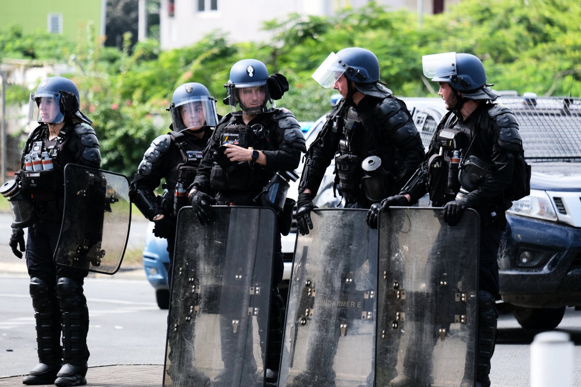 Les policiers français se tiennent avec leurs boucliers à l’entrée du quartier de la Vallée-du-Tir, à Nouméa, le 14 mai 2024.