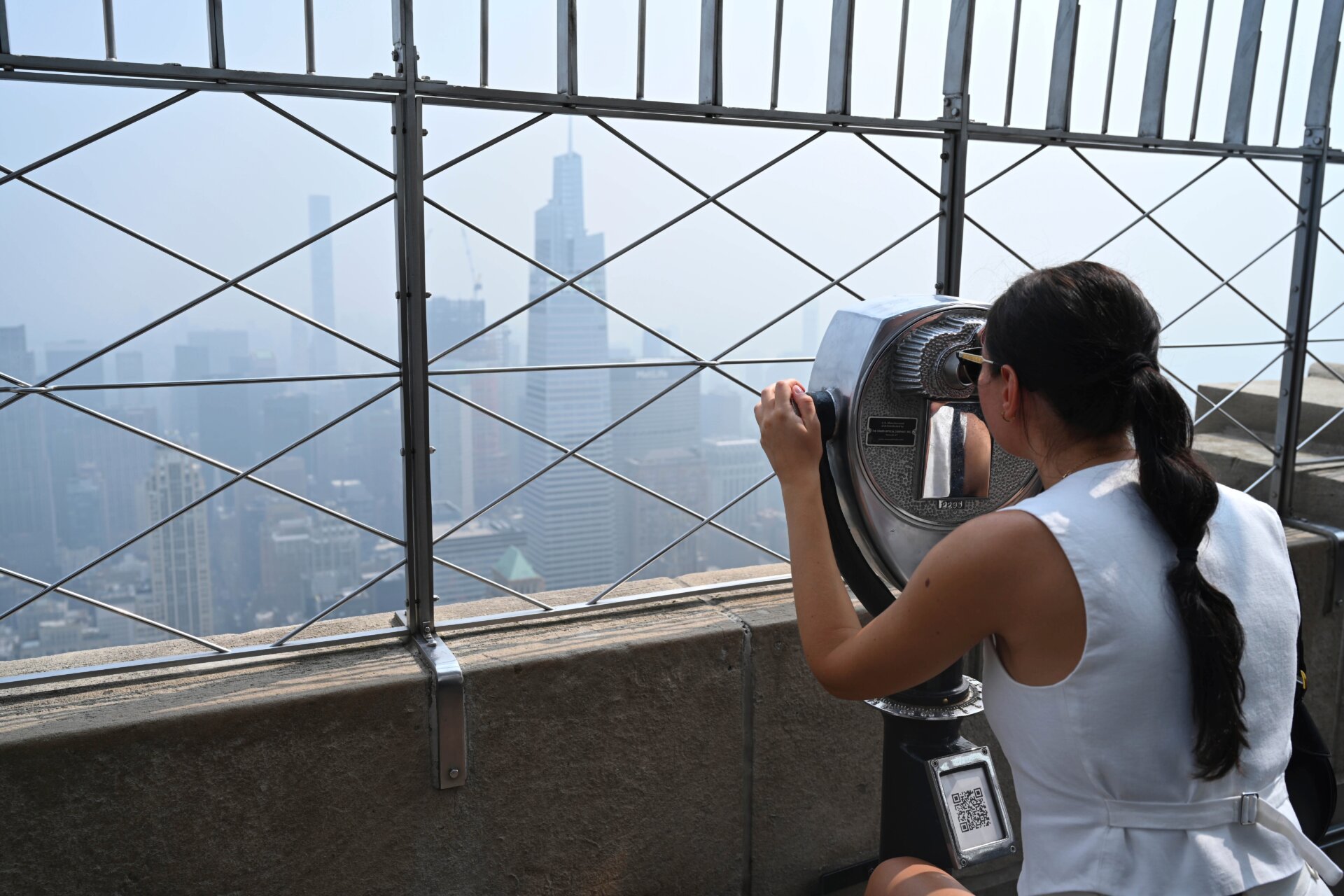 Des gens visitent la plate-forme d’observation de l’Empire State Building alors que la fumée provenant des incendies de forêt au Canada recouvre l’horizon de Manhattan le 30 juin 2023 à La ville de New York.