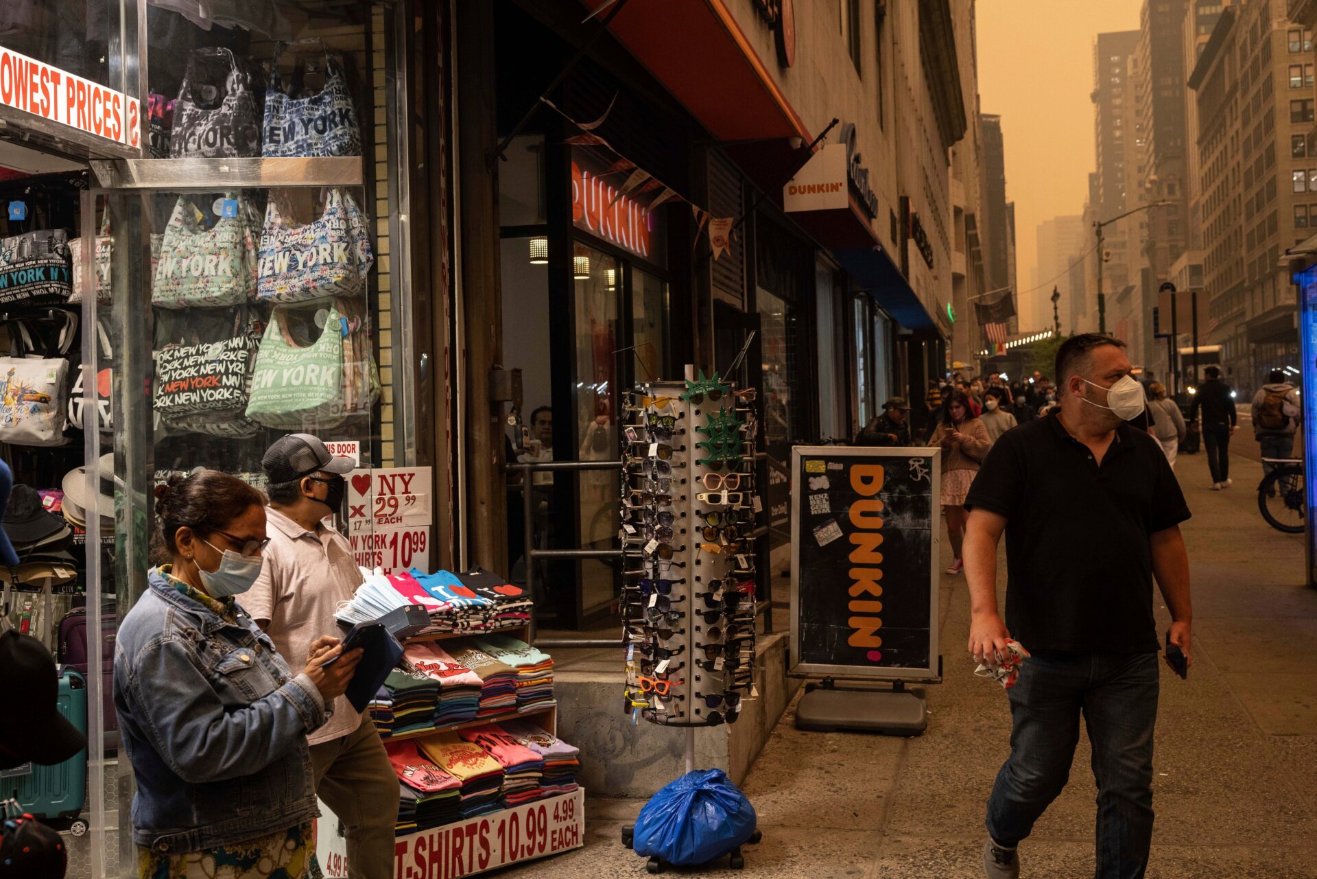 Une personne vend des masques devant un magasin de souvenirs à New York le mercredi 7 juin 2023 alors que la fumée d’un feu de forêt engloutit la ville. 