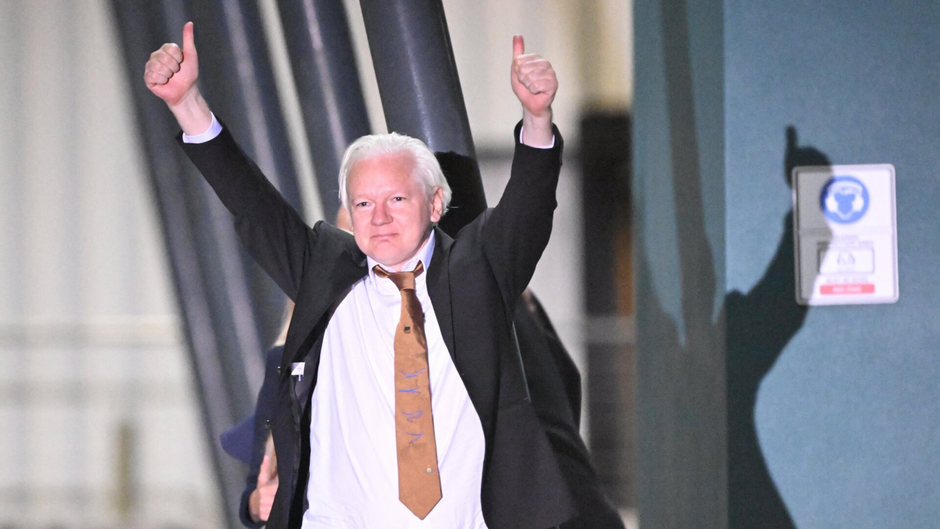 Le fondateur de WikiLeaks, Julian Assange, lève le pouce après son arrivée à l’aéroport de Canberra, en Australie, le 26 juin 2024.