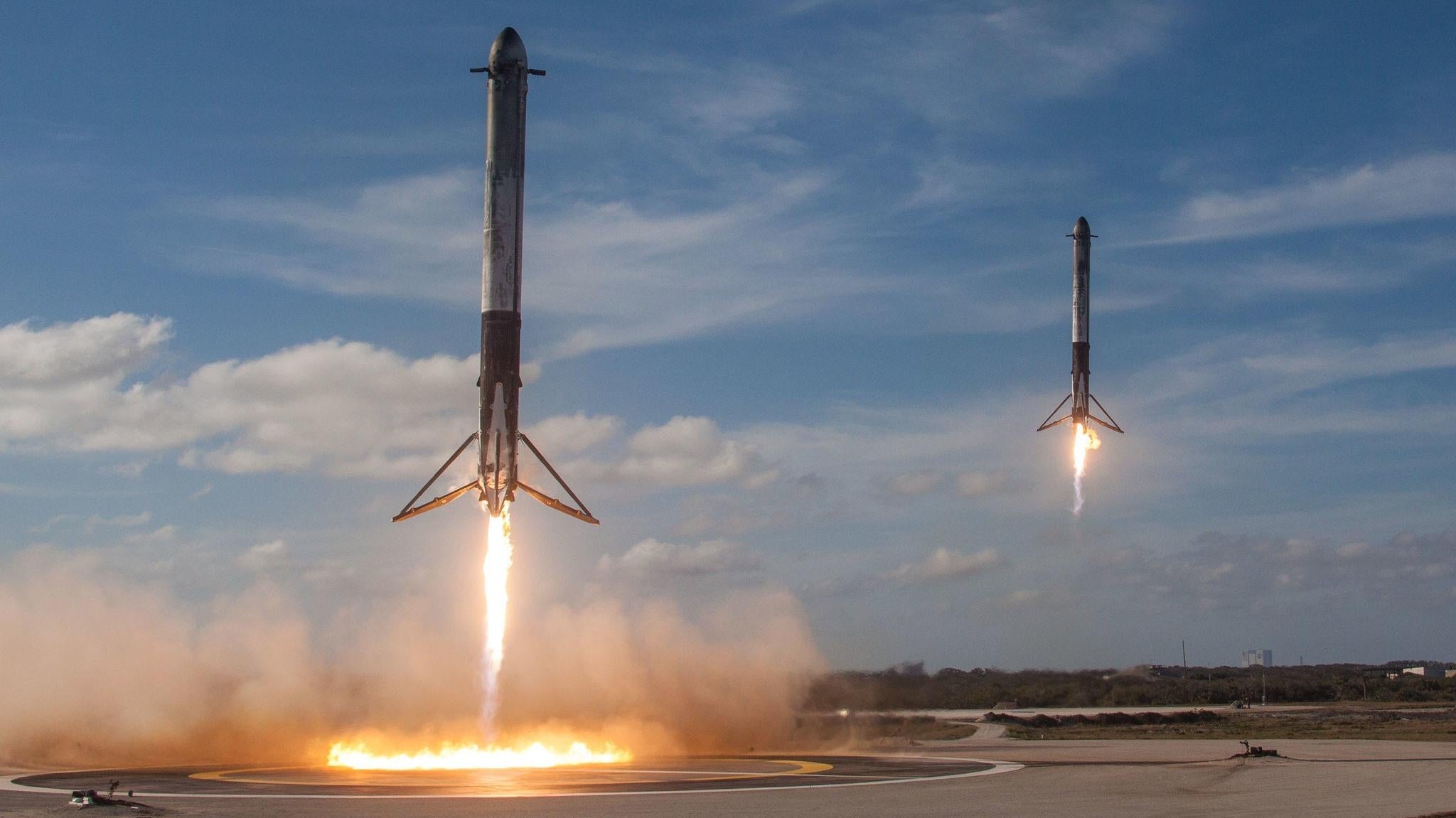 Une paire de boosters latéraux Falcon Heavy revenant pour un atterrissage lors du vol inaugural de la fusée en 2018.